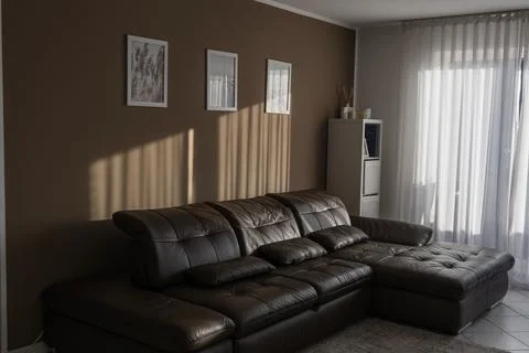 Interior of a modern living room with brown leather sofa and window Stock Photos