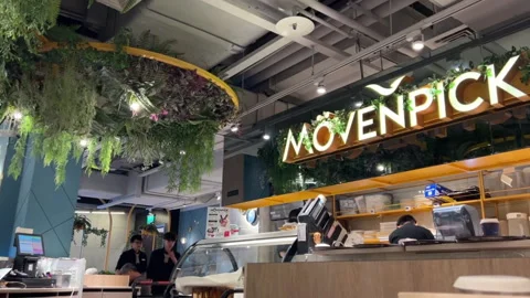 Interior of a Modern Movenpick Ice Cream Shop with Lush Greenery Stock Footage 335874787