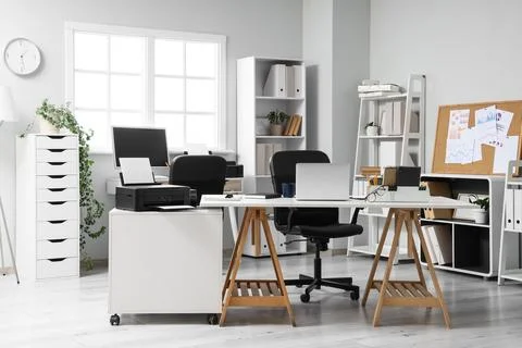 Interior of modern office with printer on desk and shelf units Stock Photos