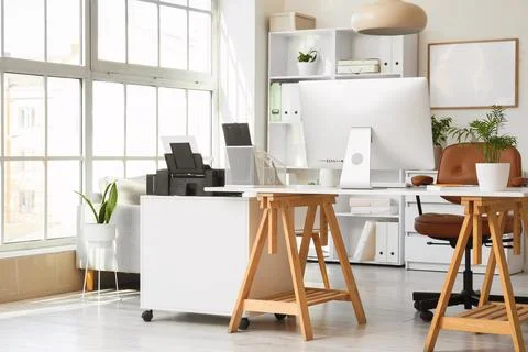 Interior of modern office with printer on desk and plants Stock Photos