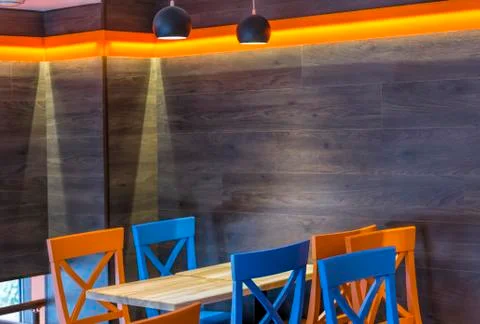 Interior of a modern pub or cafe with colorful chairs and wooden tables inter 写真素材