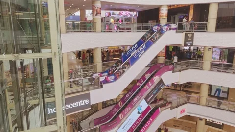 Interior of modern shopping mall with escalators connecting multiple retail Stock Footage 342714177