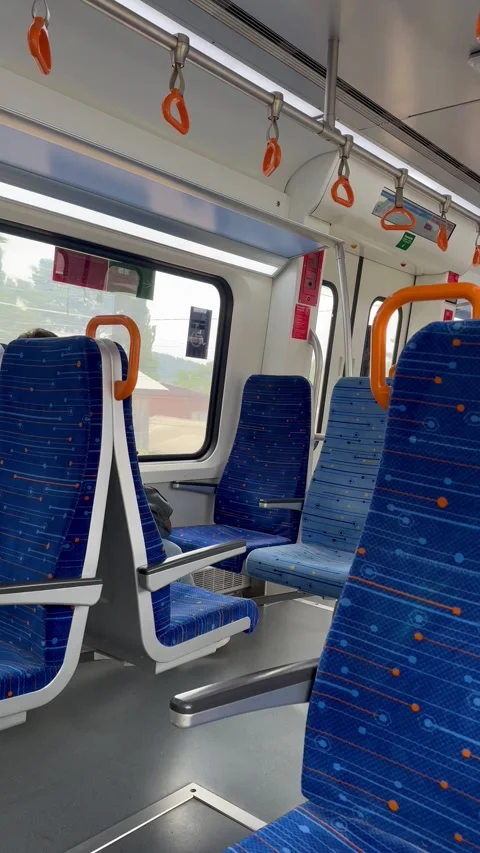 Interior of a moving train with blue and orange seats. Stock Footage 323947205