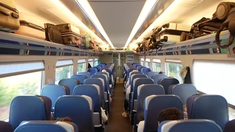 Interior of a Moving Train Car With Seated Passengers and Luggage on the Shelves Video stock 244815691