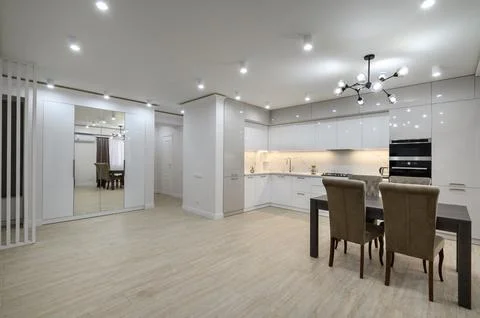 Interior of new spacious white kitchen after renovation in studio apartmen Stock Photos