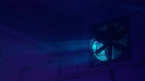 Interior night shot of an empty basement. Blue light, dirty window and fan.  Video stock 236090207