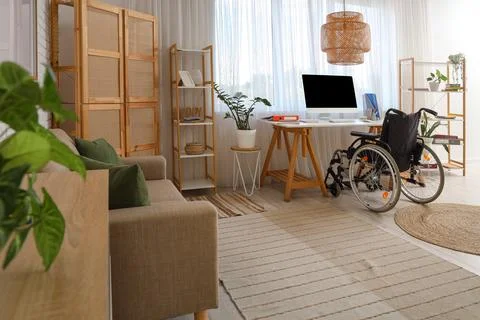 Interior of office with shelf units, workplace and wheelchair Stock Photos