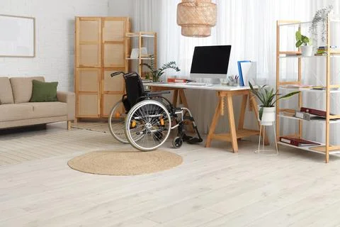 Interior of office with shelf units, workplace and wheelchair Stock Photos