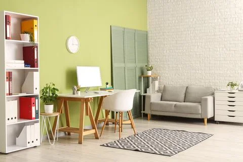 Interior of office with workplace, sofa and wall clock Stock Photos
