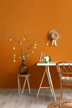 Interior of office with workplace, tree branches and Easter eggs in vase Stock Photos