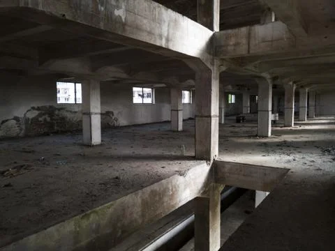Interior of an old abandoned concrete hall. Empty messy industrial warehouse Stock Photos