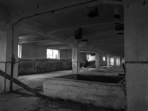 Interior of an old abandoned concrete hall. Empty messy industrial warehouse. Stock Photos