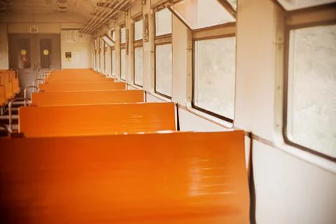 The interior of an old empty retro train car with orange seats on a bright da Stock Photos