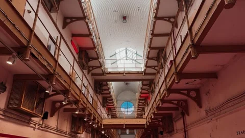 Interior of an old prison corridor with metal walkways and cells, perspective Stock Footage 334134625