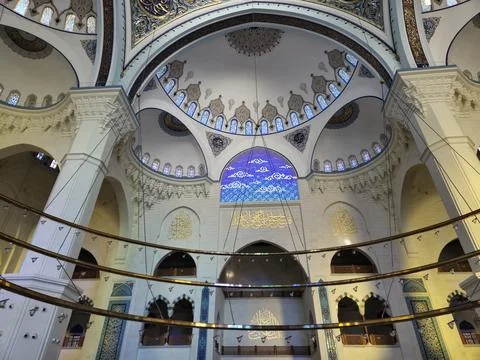 Interior of ornate mosque with arched windows and blue lighting Stock Photos