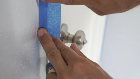 Interior Painter Using Masking Tape to Secure Wooden Window Frame. Stock Footage 129137547
