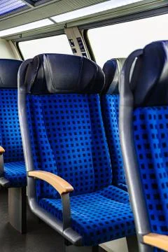 Interior of passenger train with blue empty seats Stock Photos