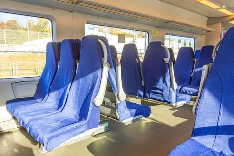Interior of a passenger train with empty blue seats. Stock Photos