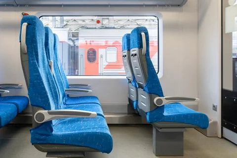 Interior of the passenger train with empty blue fabric seats Stock Photos