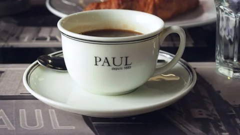 Interior of Paul cafe. Close-up of mug with hot coffee and word PAUL on the top Stock Footage 158154237