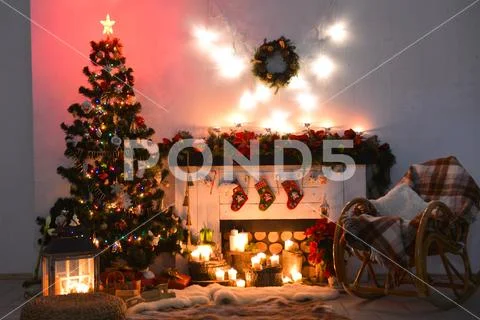 Interior photo studio with Christmas decor. Fireplace, Christmas tree, gifts of Stock Photos
