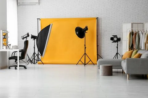 Interior of photo studio with yellow backdrop, sofa and makeup table Stock Photos