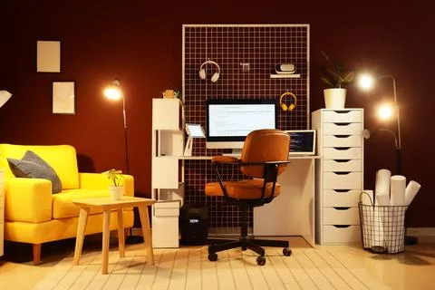 Interior of programmer's office with workplace, armchair and glowing lamps Stock-Fotos