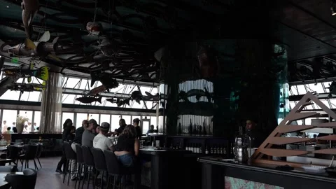 Interior of a restaurant with hanging fish sculptures and bar seating Stock Footage 336350351