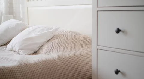 The interior of the room in beige tones with a bed and pillow, closet and Stock Photos