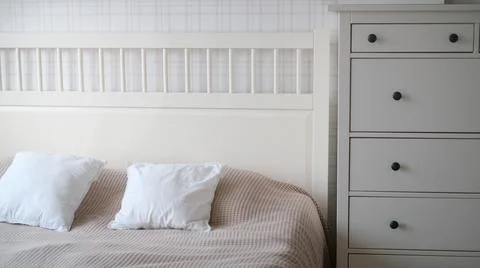The interior of the room in beige tones with a bed and pillow, closet and Stock Photos