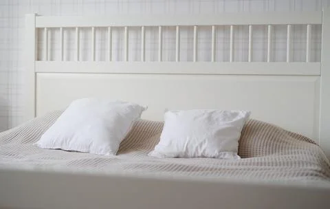 The interior of the room in beige tones with a bed and pillow, closet and Stock Photos
