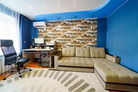 Interior of the room with corner sofa, Desktop with computer and printer. Stock Photos