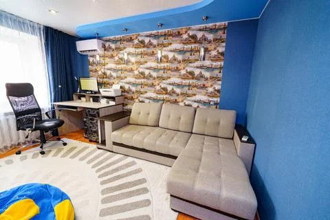 Interior of the room with corner sofa, Desktop with computer and printer. Stock Photos
