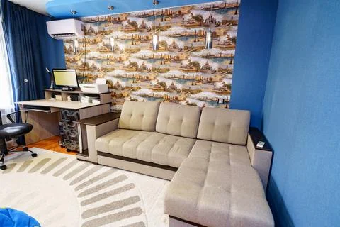 Interior of the room with corner sofa, Desktop with computer and printer. Stock Photos