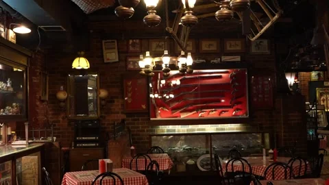 Interior of rustic restaurant with red checkered tablecloths and gun display Stock Footage 336350097
