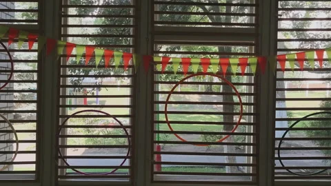 Interior of a school gym or kindergarten classroom. Hula hoops and festive flag Stock Footage 345680043