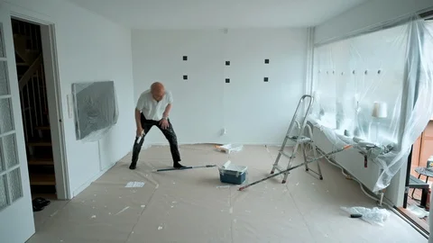 Interior shot of active senior making home improvements by painting walls Stock Footage 107273742