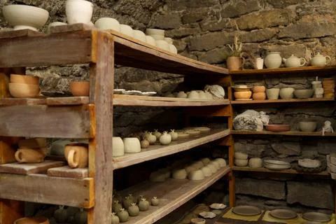 Interior shot of an authentic pottery workshop showing raw unfired clay cups. Stock Photos