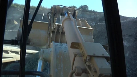 Interior shot of a loader loading granite aggregate into a hauler. Stock Footage 97960294