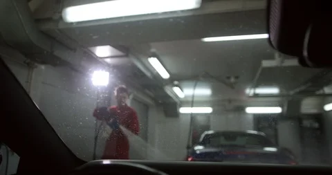 An interior shot of a man taking a car through a car wash with water and foam. Stock Footage 94899541