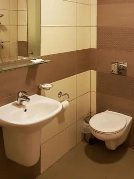 The interior of the small bathroom is done in soft and warm beige colors. Pla Stock Photos