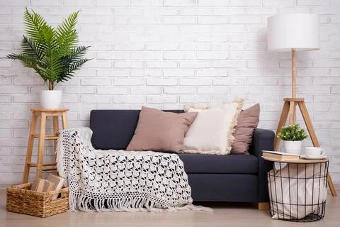 Interior with sofa, table and lamp over brick wall Stockfoto's