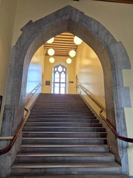 Interior staircase in arched hall with warm pendant lights Stock Photos