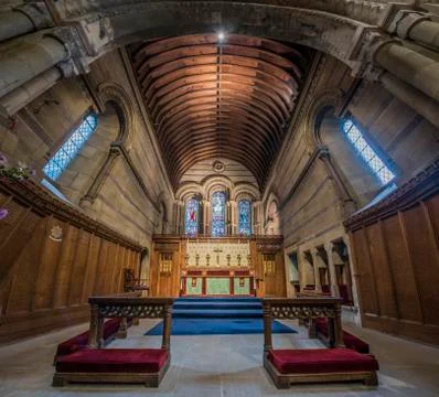 Interior of a stone chapel or small rural church with wooden paneling and pew Stock Photos