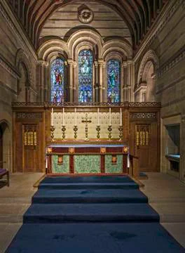 Interior of a stone chapel or small rural church with wooden paneling and pew Stock Photos
