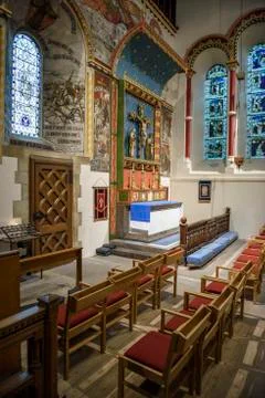 Interior of a stone chapel or small rural church with wooden paneling and pew Stock Photos