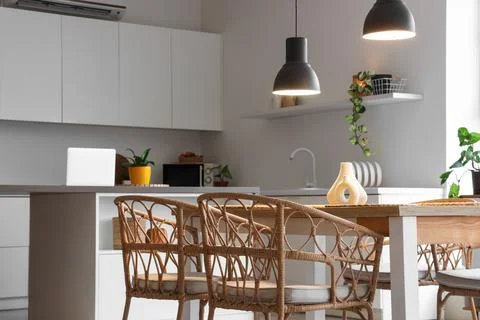 Interior of stylish dining room with table, houseplants and glowing lamps Stock Photos