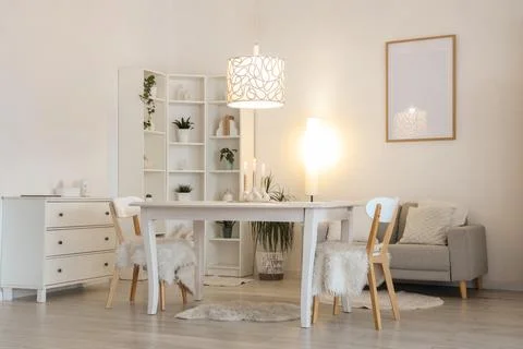 Interior of stylish dining room with table, burning candles and glowing lamps Stock Photos