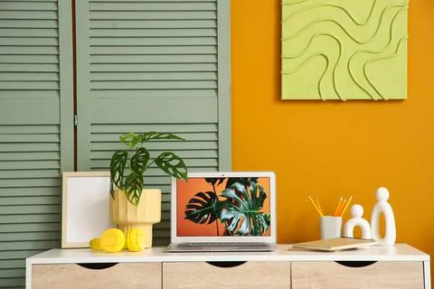 Interior of stylish office with workplace, folding screen and painting Stock Photos