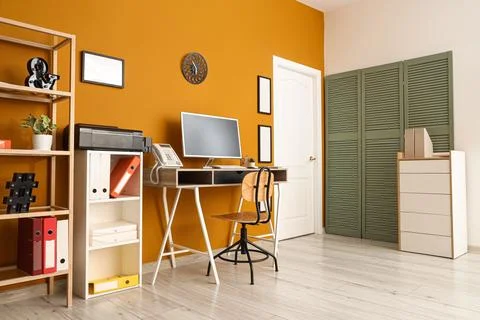 Interior of stylish office with workplace, shelf units and wall clock Stock Photos